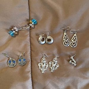 Six pairs of silver tone earrings